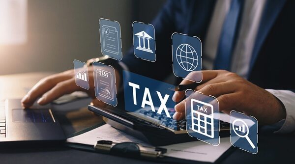 Business person using a laptop to complete income tax return for Business person using a laptop to complete income tax return for